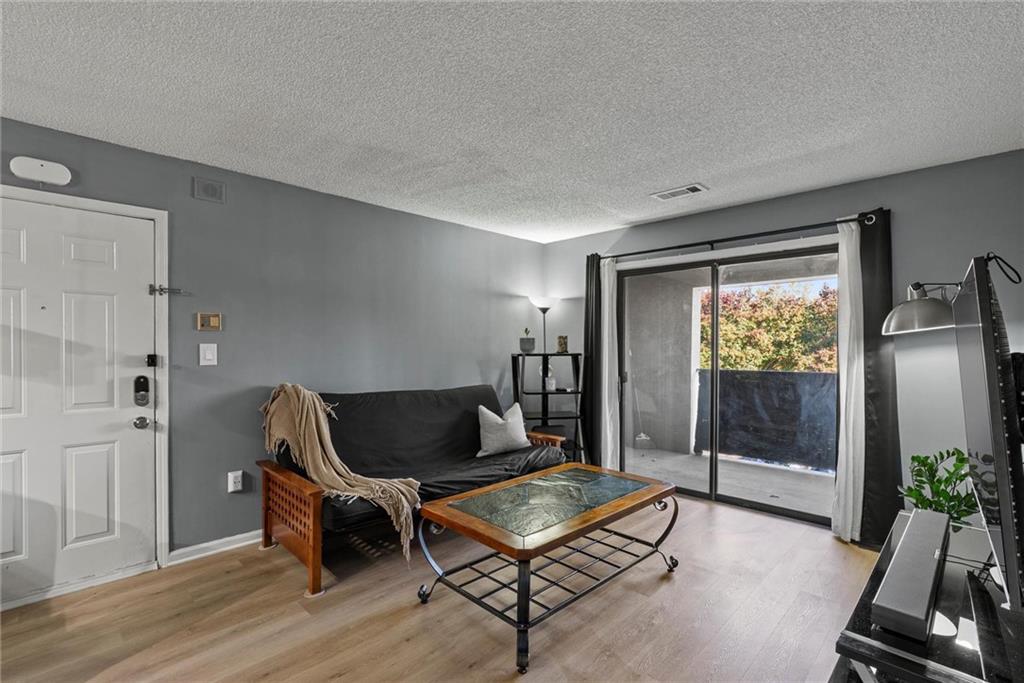 2657 Lenox Road Northeast, Unit L 163 Atlanta, GA 30324 - Photo 3 of 34 a living room with furniture gym equipment and glass door