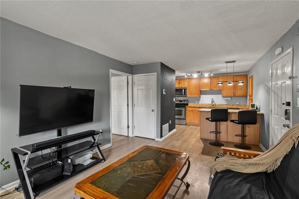 2657 Lenox Road Northeast, Unit L 163 Atlanta, GA 30324 - Photo 5 of 34 a living room with furniture and a flat screen tv