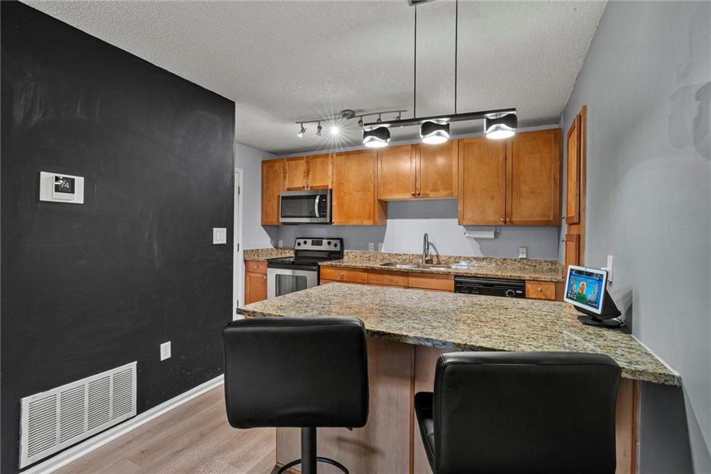 2657 Lenox Road Northeast, Unit L 163 Atlanta, GA 30324 - Photo 7 of 34 a kitchen with a sink a counter top space cabinets and stainless steel appliances