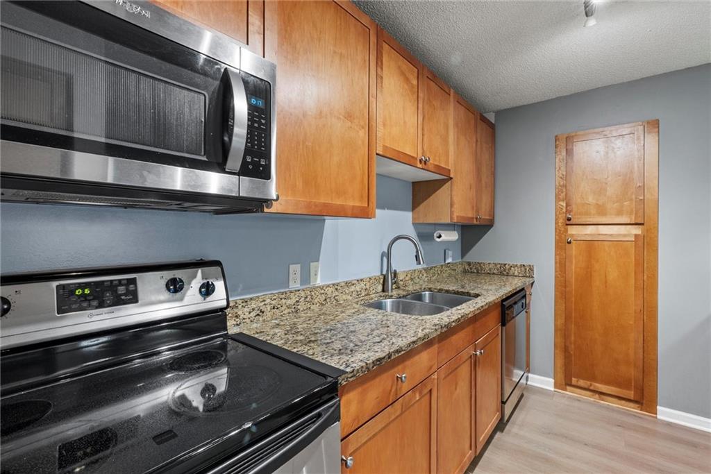 2657 Lenox Road Northeast, Unit L 163 Atlanta, GA 30324 - Photo 10 of 34 a kitchen with granite countertop stainless steel appliances and wooden cabinets