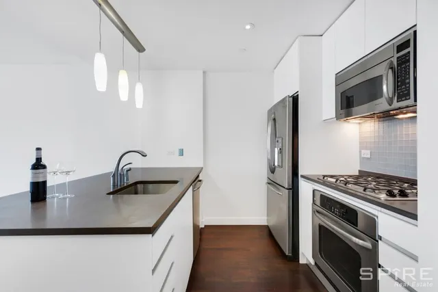a kitchen with stainless steel appliances kitchen island a stove and a sink
