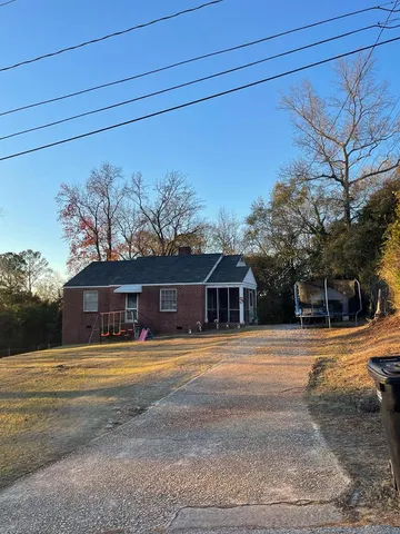 a front view of a house with a yard and trees