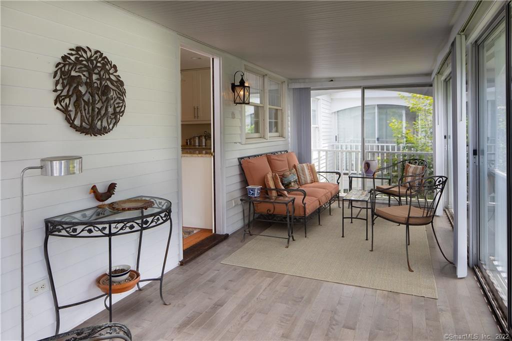 Sun porch with new flooring & view onto expansive open green space.