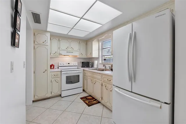 a kitchen with stainless steel appliances a refrigerator sink and cabinets