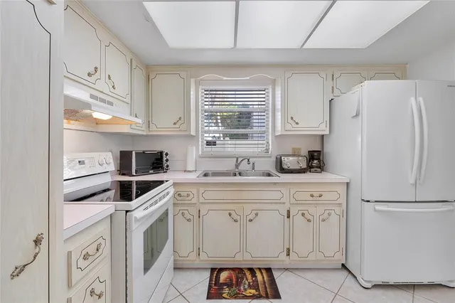 a kitchen with white cabinets and white appliances