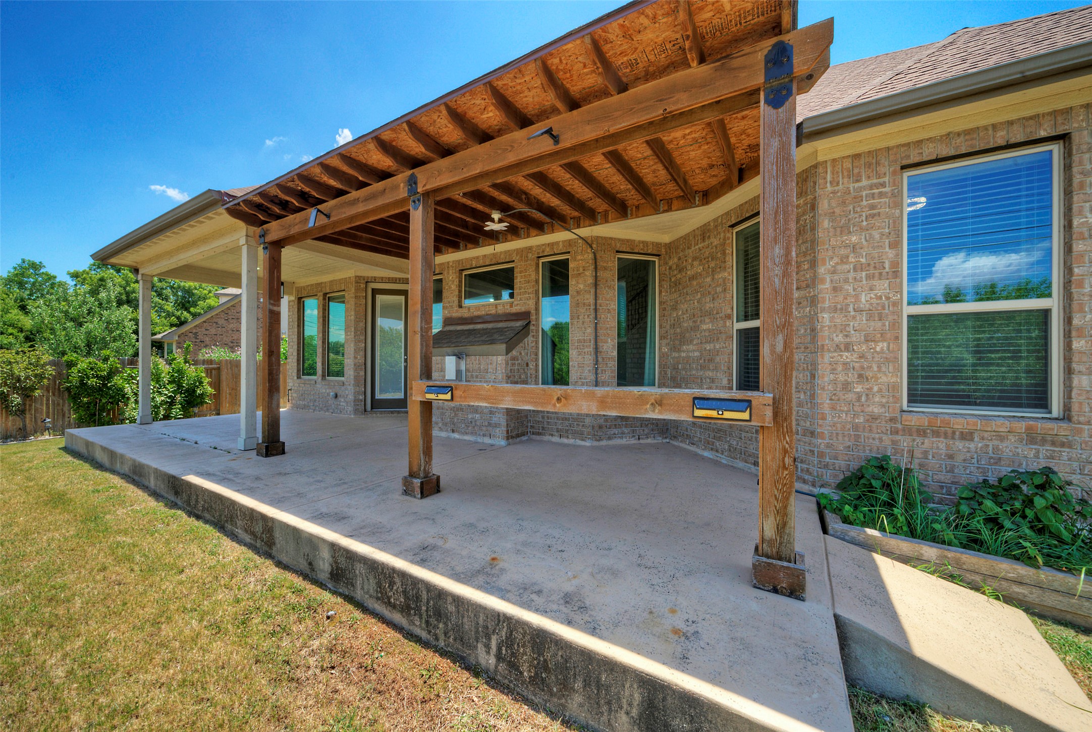2260 Hat Bender Loop Round Rock, TX 78664 - Photo 36 of 40 A spacious concrete patio extends from the brick-clad home, offering both shaded and open-air relaxation.