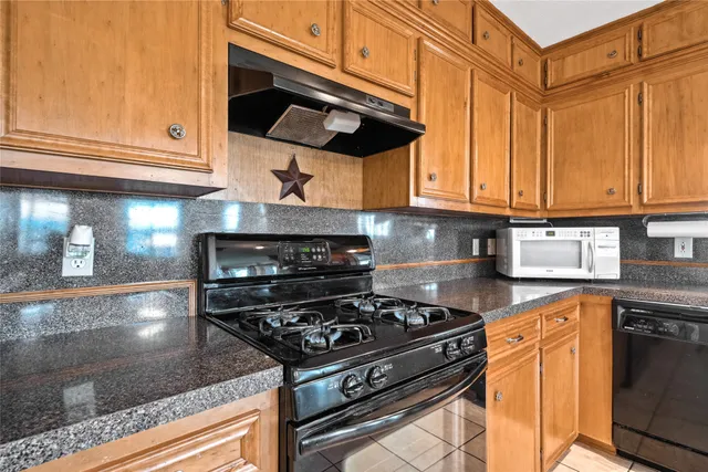 a kitchen with stainless steel appliances granite countertop a stove and a microwave
