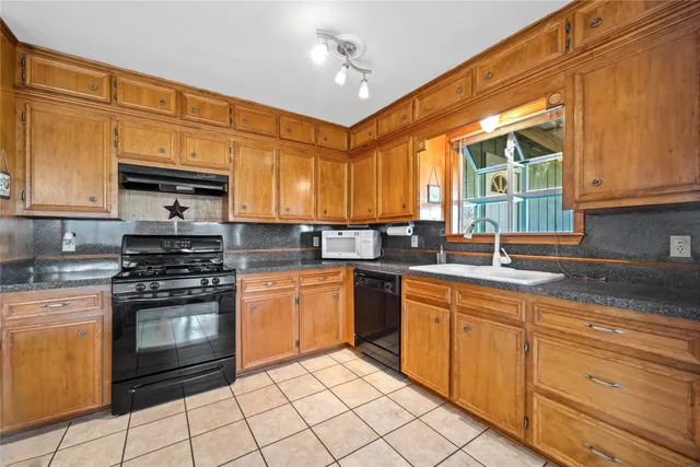 a kitchen with stainless steel appliances granite countertop a stove sink and cabinets