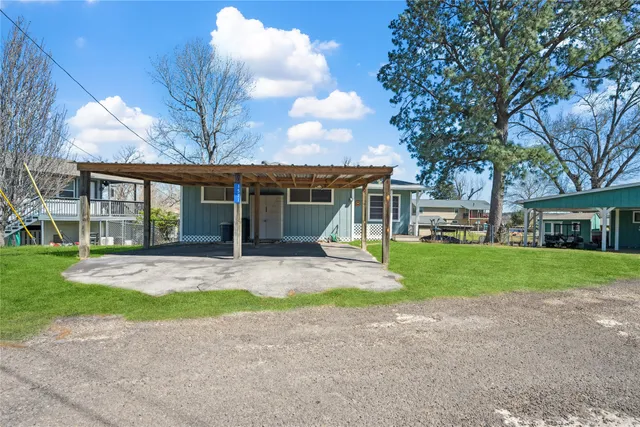 a front view of a house with a yard and trees