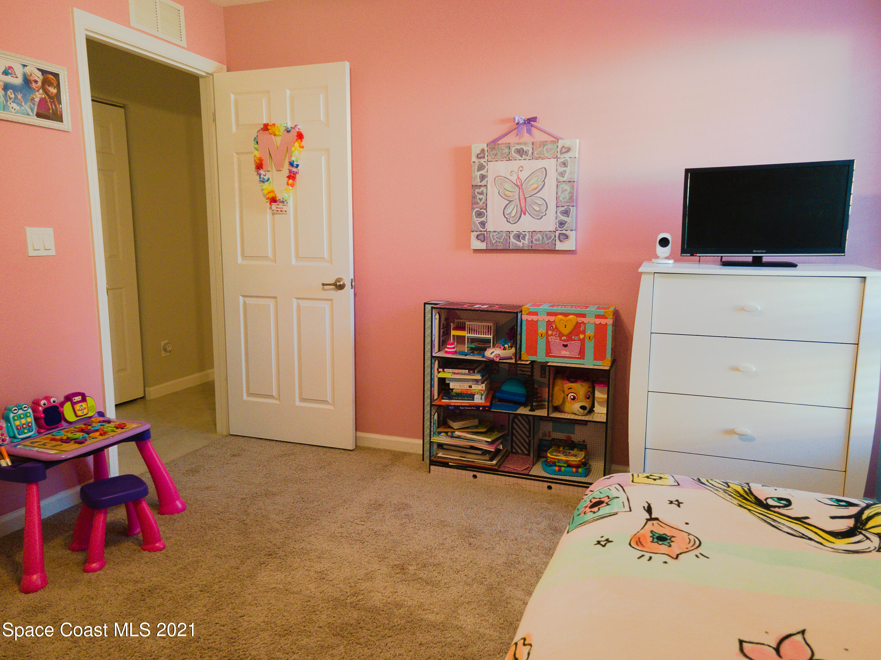 1525 Talbott Street Palm Bay, FL 32909 - Photo 12 of 31 a bedroom with a bed and a flat tv screen on dresser