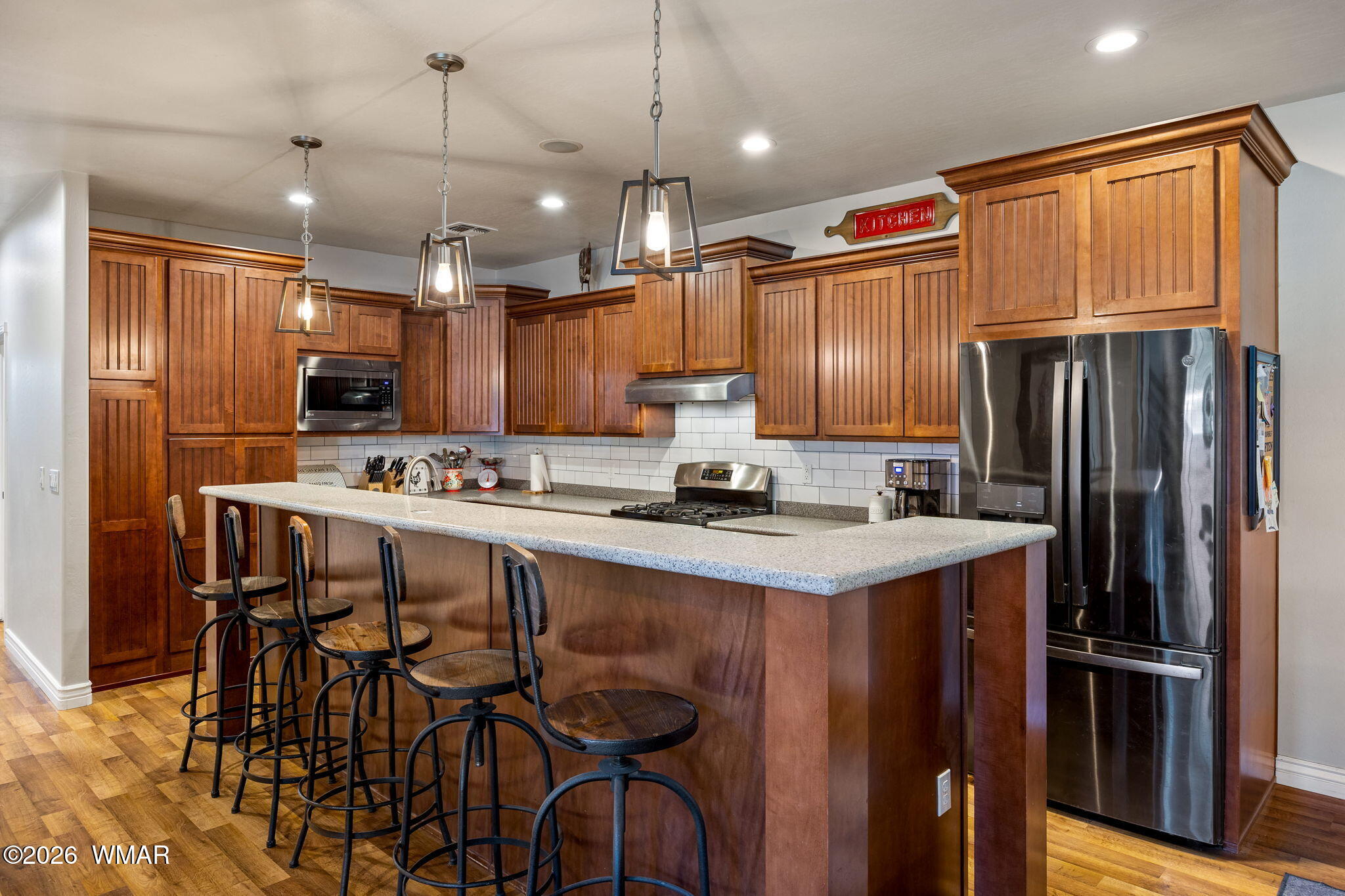1940 Stonegate Way Heber, AZ 85928 - Photo 15 of 62 a kitchen with stainless steel appliances granite countertop a refrigerator a stove a sink a dining table and chairs with wooden floor