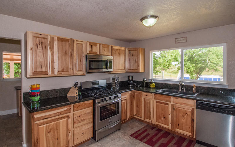 22014 Lone Tree Road Anderson, CA 96007 - Photo 3 of 19 a kitchen with granite countertop a sink cabinets stainless steel appliances and a window