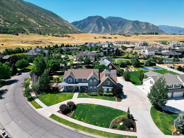 672 Perry Hollow Drive Mapleton, UT 84664 - Photo 11 of 106 Two-story residence with blue siding and stone accents on a curved street