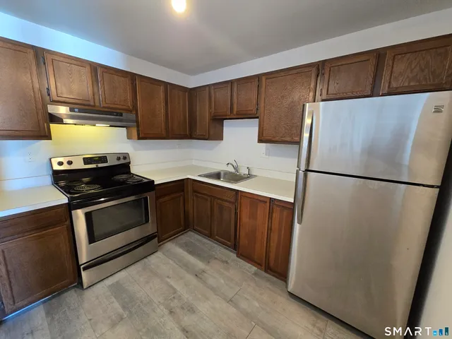 a kitchen with a refrigerator sink and cabinets