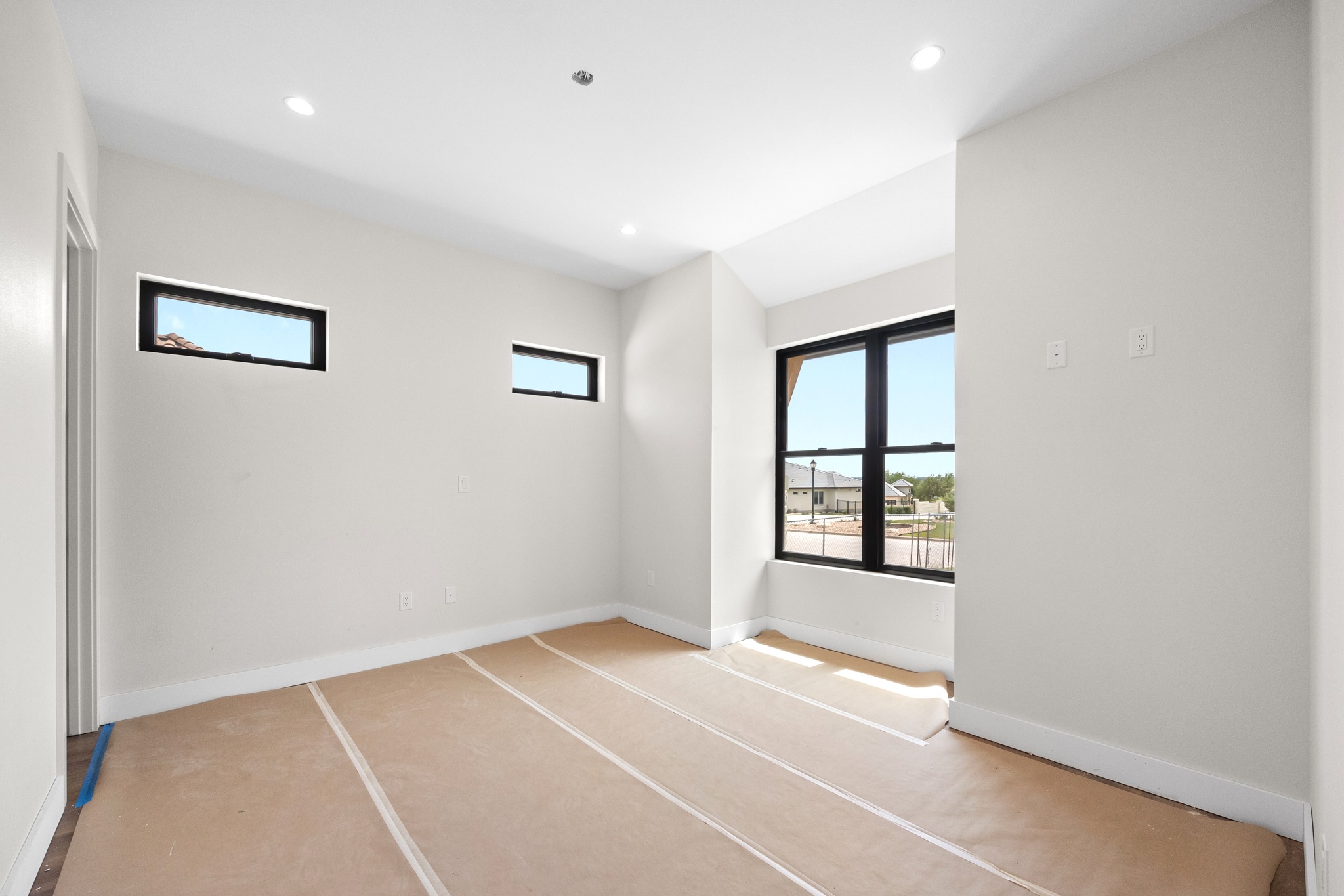903 Flint Ridge Trail Georgetown, TX 78628 - Photo 16 of 39 Bright room featuring a large black-framed window and two transom windows, recessed lighting, and white baseboards