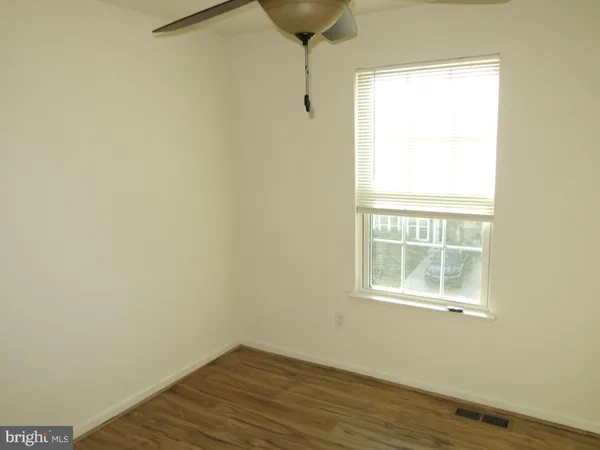 a view of a small space with wooden floor and a window