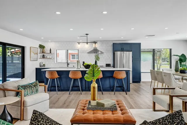 a living room with furniture kitchen view and a chandelier