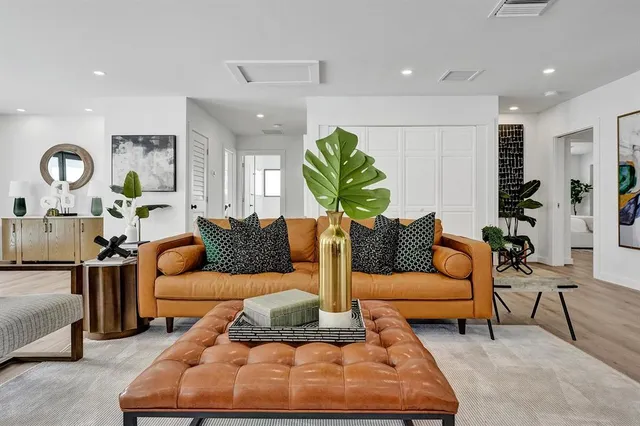 a living room with furniture rug and wall paintings