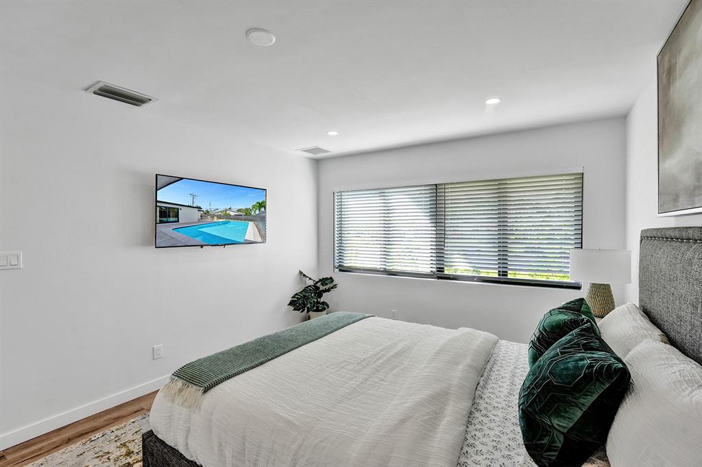 5501 Northeast 18th Terrace Fort Lauderdale, FL 33308 - Photo 21 of 56 a bedroom with a bed and a painting on the wall