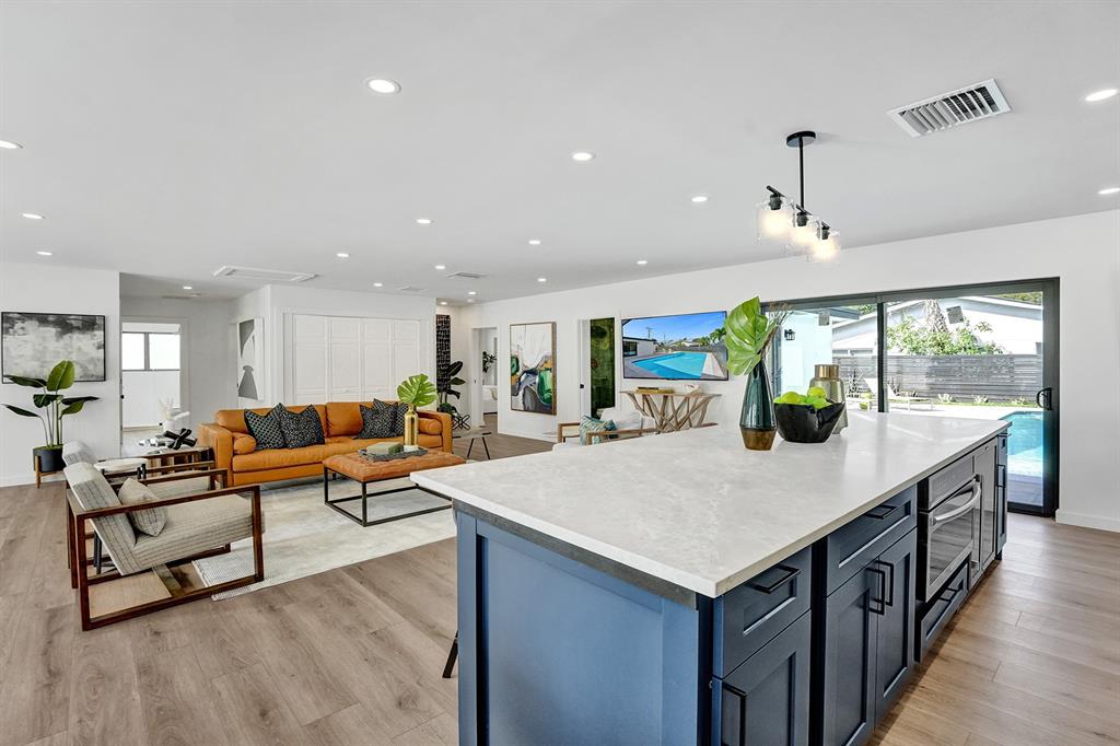 5501 Northeast 18th Terrace Fort Lauderdale, FL 33308 - Photo 40 of 56 a large living room with stainless steel appliances kitchen island a table chairs and a counter top space