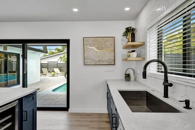 a kitchen with stainless steel appliances granite countertop a sink a stove and a wooden floor