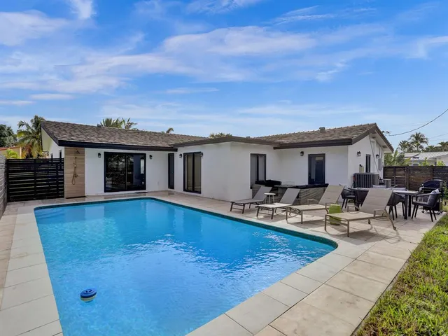 a view of a house with swimming pool and sitting area