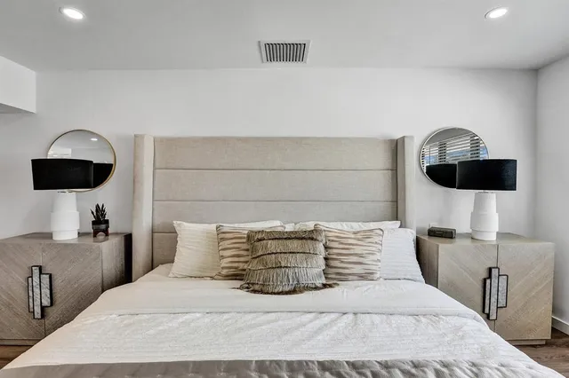 a bedroom with a bed a couch and a flat screen tv