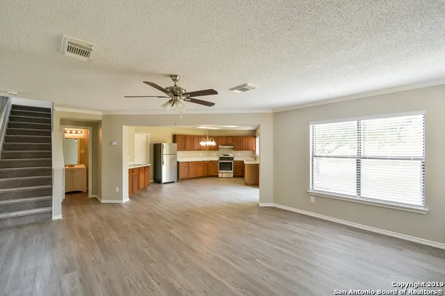 an empty room with wooden floor closet and windows