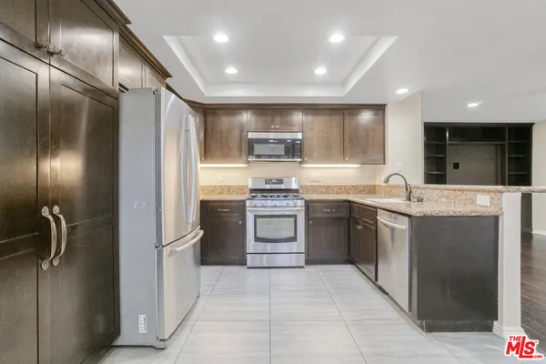 a kitchen with a sink stainless steel appliances and cabinets