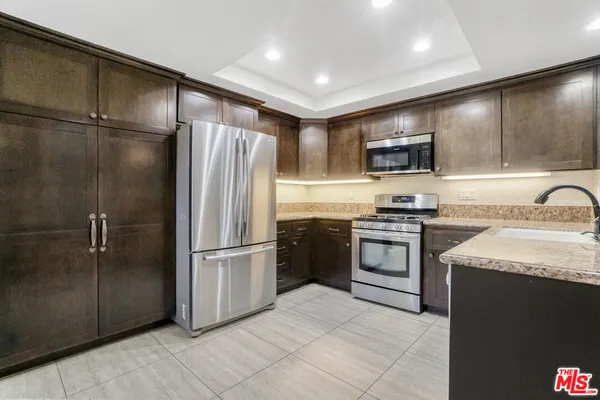 a kitchen with stainless steel appliances granite countertop a refrigerator stove and sink