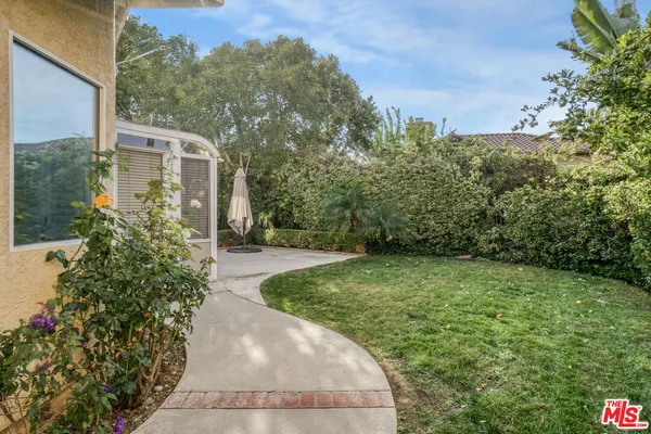 a front view of a house with a garden and yard