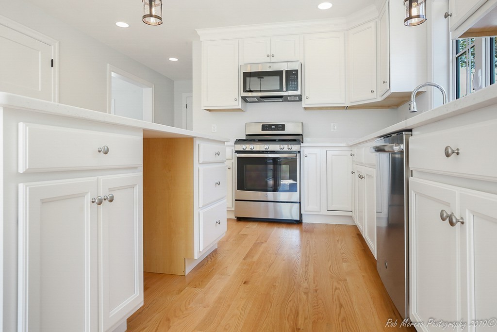 116 Bennett Hill Road Rowley, MA 01969 - Photo 12 of 39 a kitchen with stainless steel appliances a stove a microwave and a refrigerator