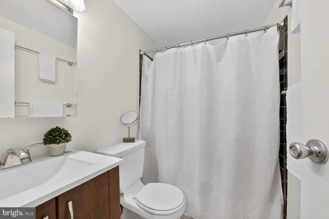a bathroom with a sink vanity mirror and toilet