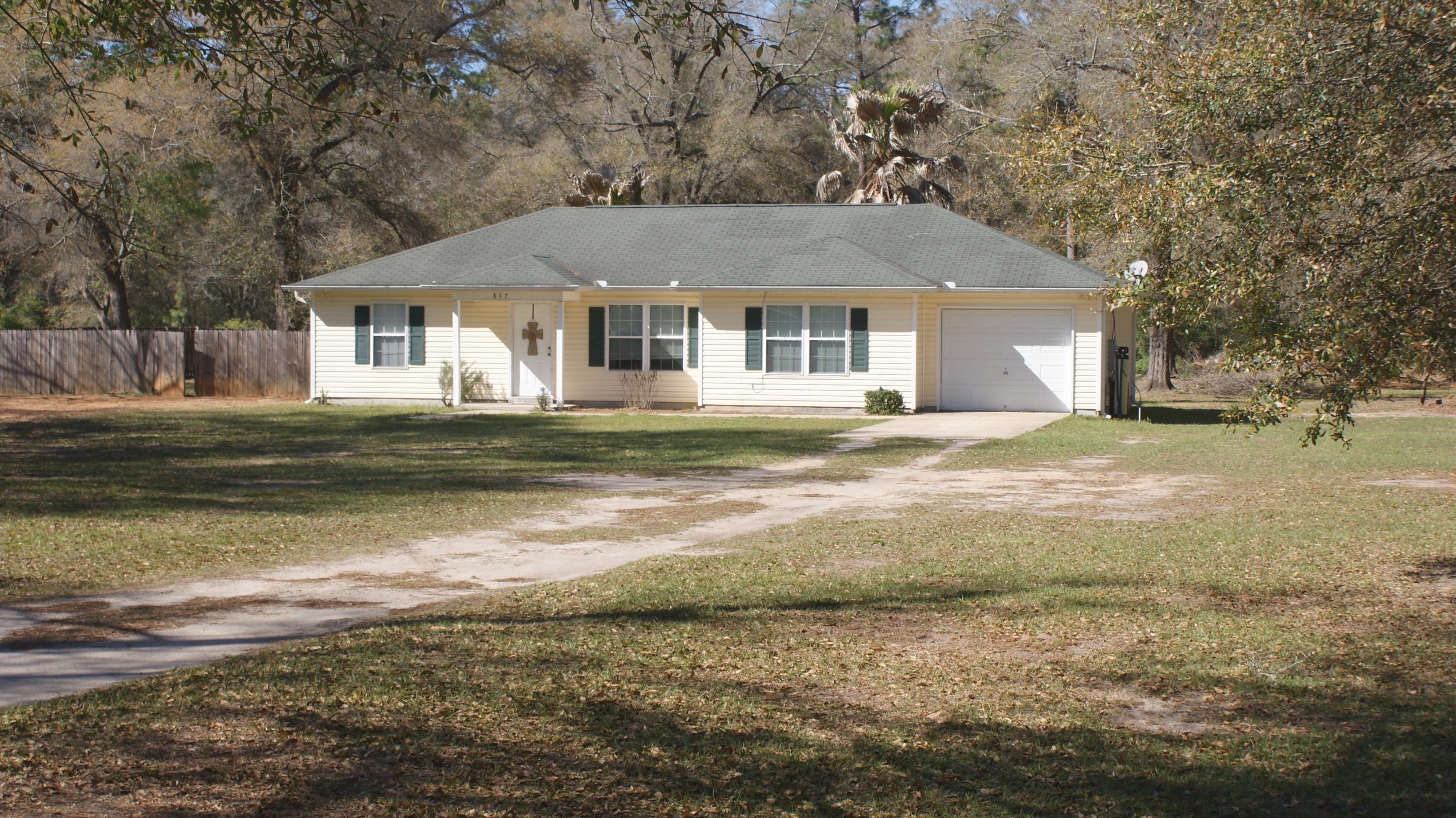 897 Lighthouse Church Road Holt, FL 32564 - Photo 1 of 15 a front view of a house with a garden