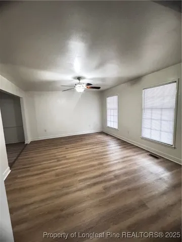 a view of an empty room with a fireplace and a fan