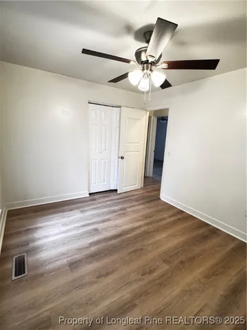 a view of a livingroom with a ceiling fan and wooden floor
