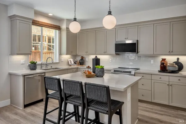 a kitchen with a dining table chairs sink and microwave