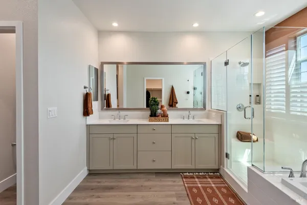 a spacious bathroom with a double vanity sink a mirror and shower