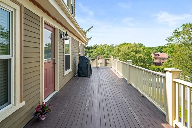 a view of a balcony with wooden floor and fence