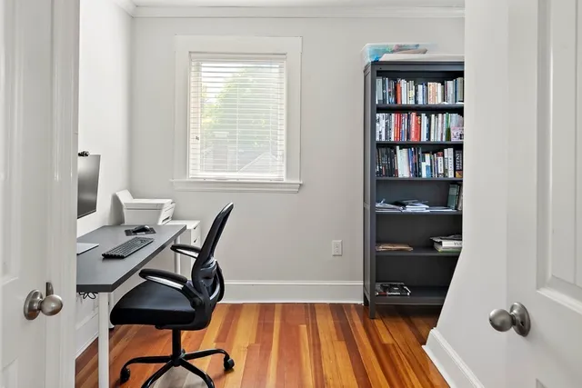 a view of a workspace with furniture and a window