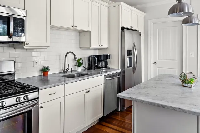 a kitchen with stainless steel appliances granite countertop a stove a refrigerator and a sink