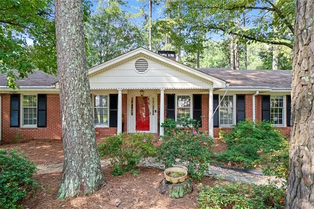 a front view of a house with a yard and potted plants