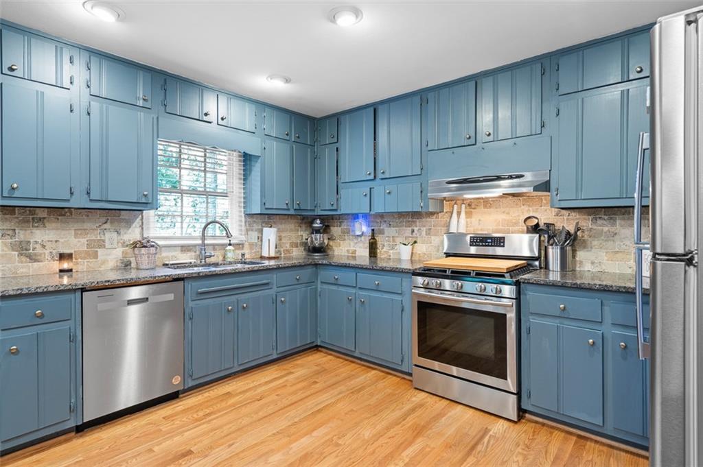 3698 Embry Circle Atlanta, GA 30341 - Photo 12 of 43 a kitchen with granite countertop wooden cabinets stainless steel appliances and a window