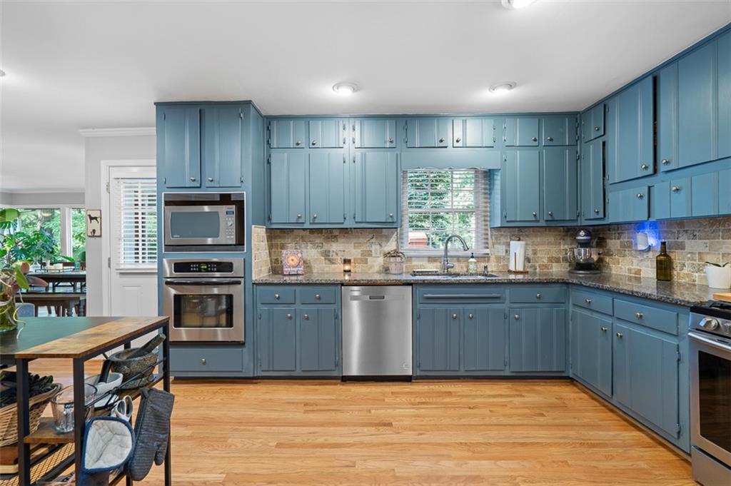 3698 Embry Circle Atlanta, GA 30341 - Photo 13 of 43 a kitchen with stainless steel appliances granite countertop wooden cabinets a stove top oven a sink and dishwasher