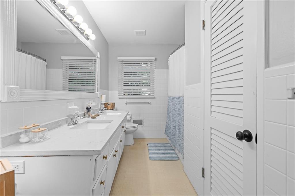 3698 Embry Circle Atlanta, GA 30341 - Photo 27 of 43 a bathroom with a double vanity sink a toilet and a shower