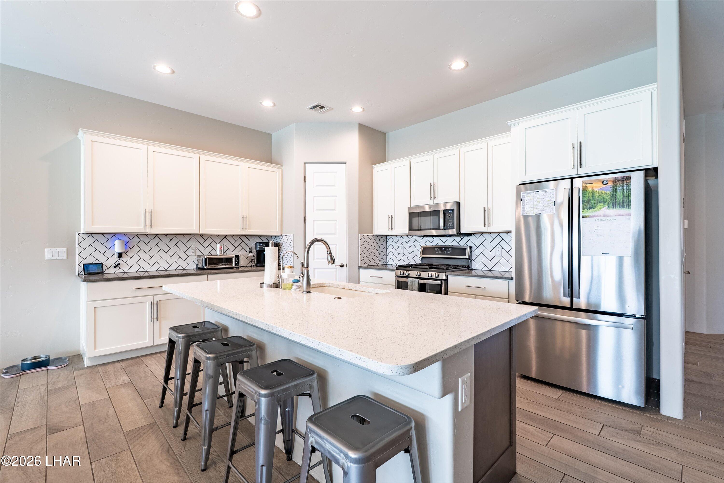 4667 North Juneberry Road Lake Havasu City, AZ 86404 - Photo 5 of 50 a kitchen with kitchen island a refrigerator stove microwave and cabinets