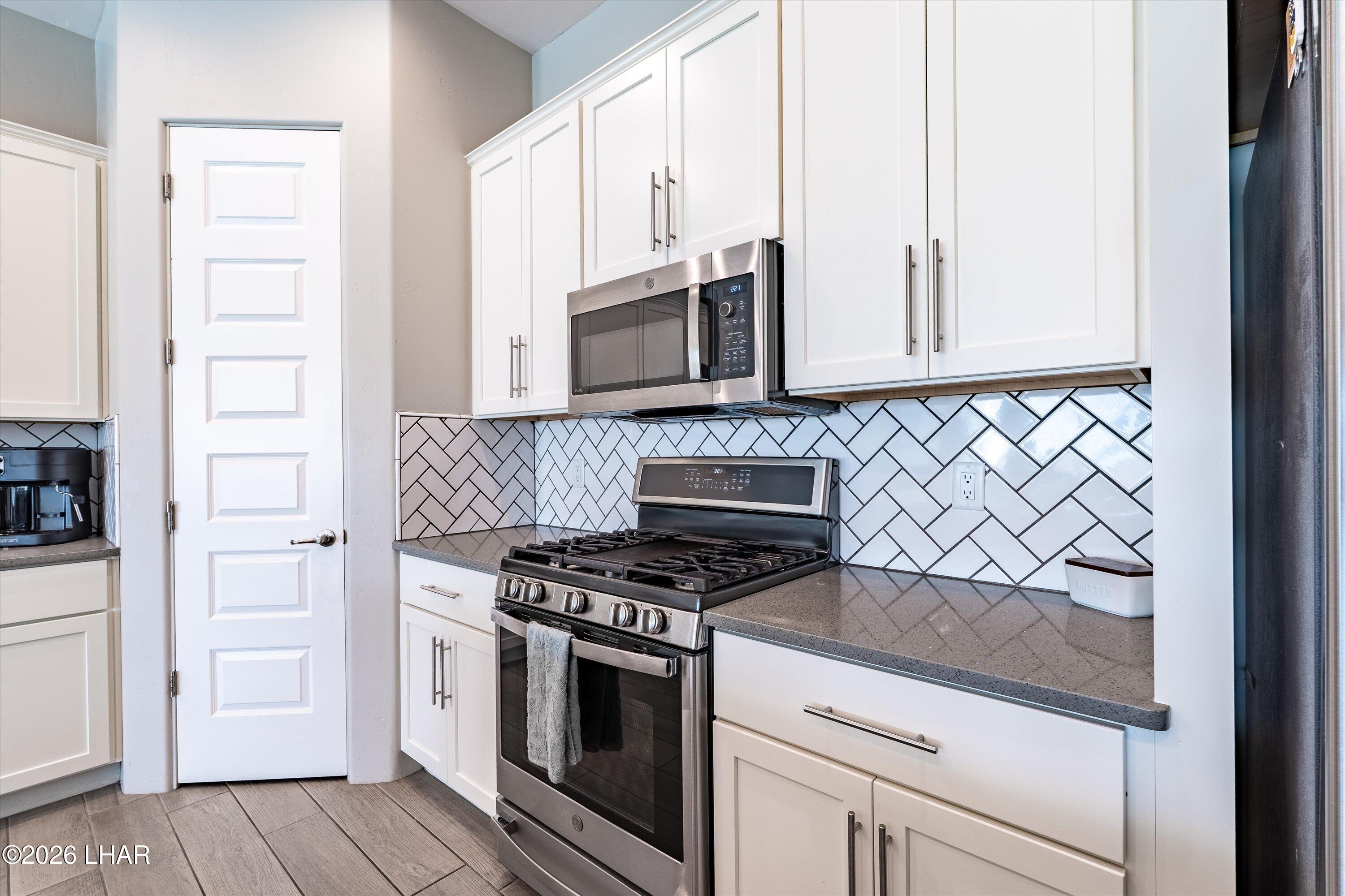 4667 North Juneberry Road Lake Havasu City, AZ 86404 - Photo 6 of 50 a kitchen with granite countertop white cabinets and stainless steel appliances