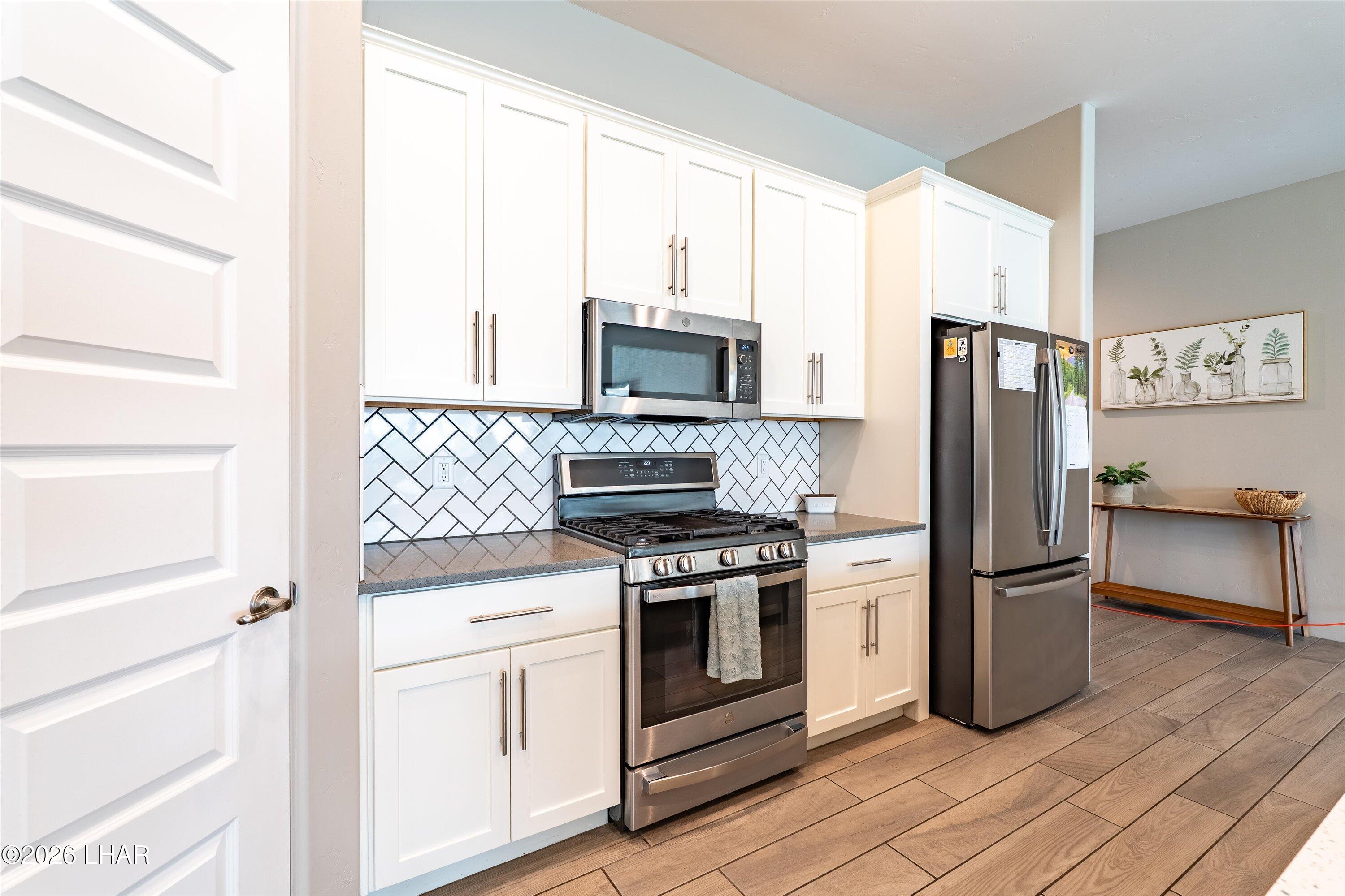 4667 North Juneberry Road Lake Havasu City, AZ 86404 - Photo 9 of 50 a kitchen with a stove refrigerator and microwave