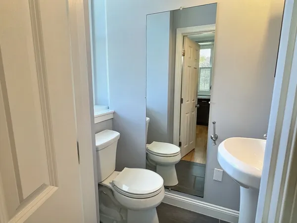 a white toilet sitting next to a bathroom sink and vanity