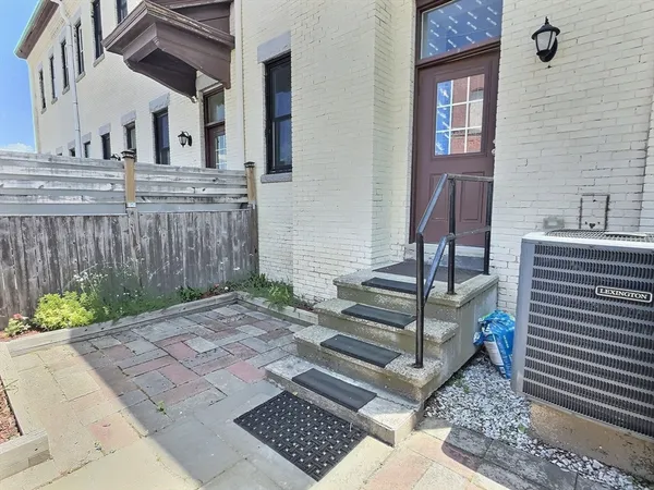 a view of a brick house with plants